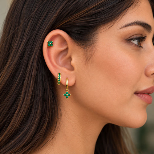 Model wearing green clover stud earring paired with gold hoop earrings by The Wish Store.