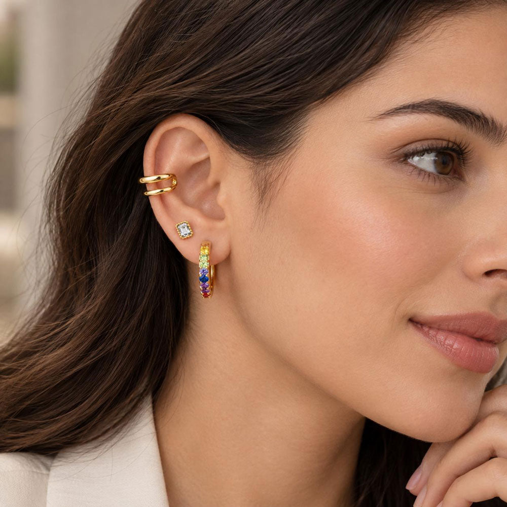 Model wearing an 18k gold plated ivory luxe cartilage stud earring, cuff and a multicolour gemstone hoops