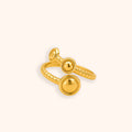 A 18K gold-toned adjustable ring with a textured band and two round dome-shaped elements, shown on a plain light beige background.