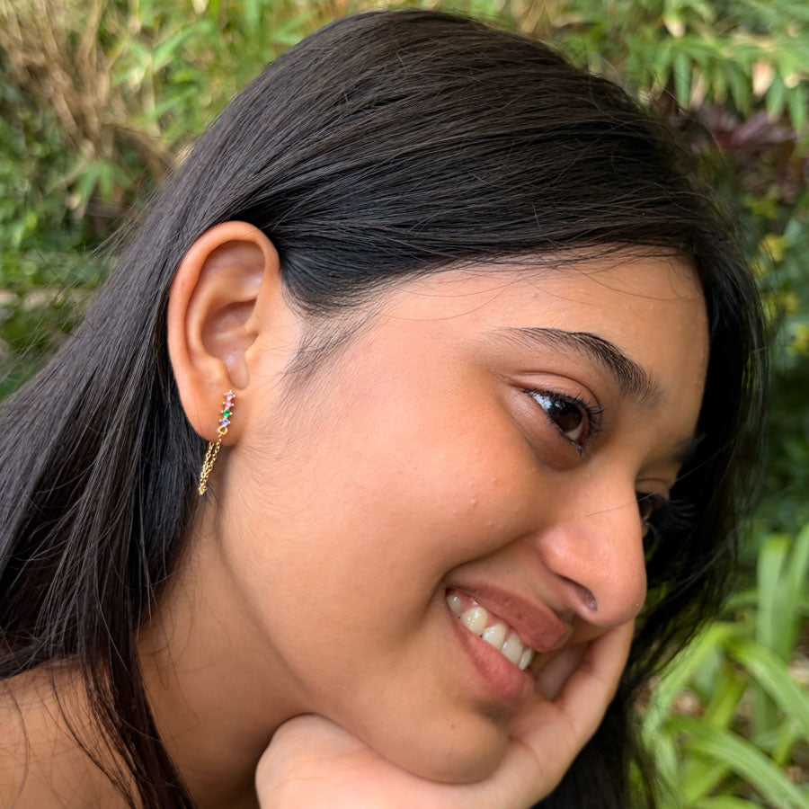 A girl wearing 18k gold plated sterling silver multicolour zircon chain stud earrings