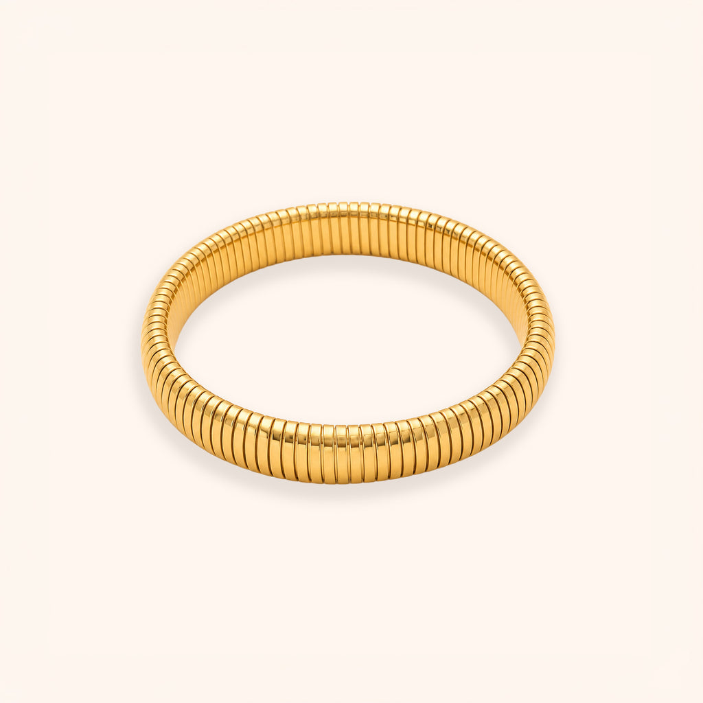 A gold-colored segmented bangle bracelet with a textured, ribbed design, displayed on a clean off-white background.