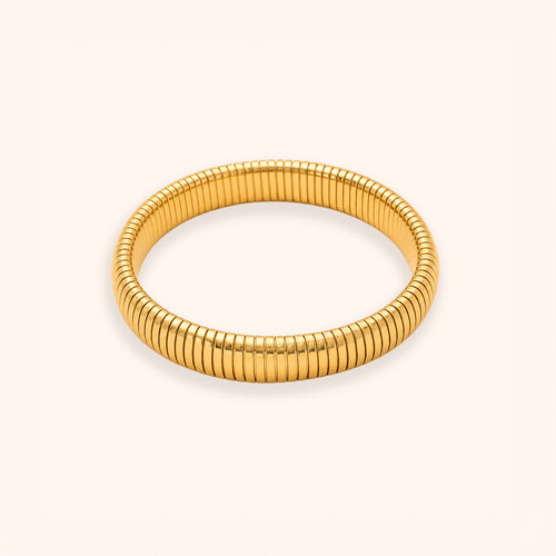 A gold-colored segmented bangle bracelet with a textured, ribbed design, displayed on a clean off-white background.