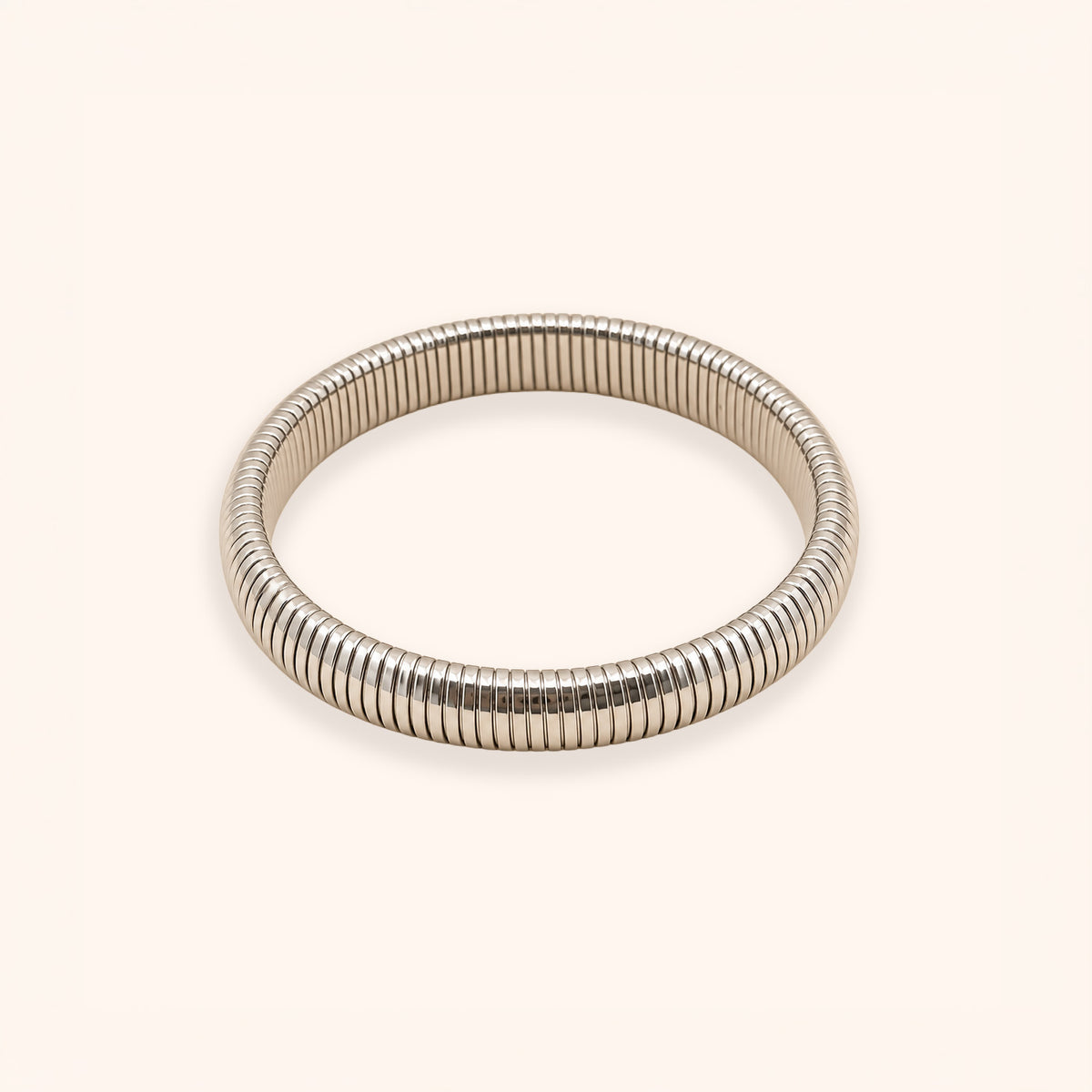 A silver-toned metal bangle bracelet with a textured, ribbed snake-skin style pattern, shown on a plain light beige background.